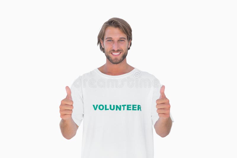 T-shirt volontaire de port d'homme heureux renonçant à des pouces photographie stock T-shirt volontaire de port d'homme heureux renonçant à des pouces photographie stock
