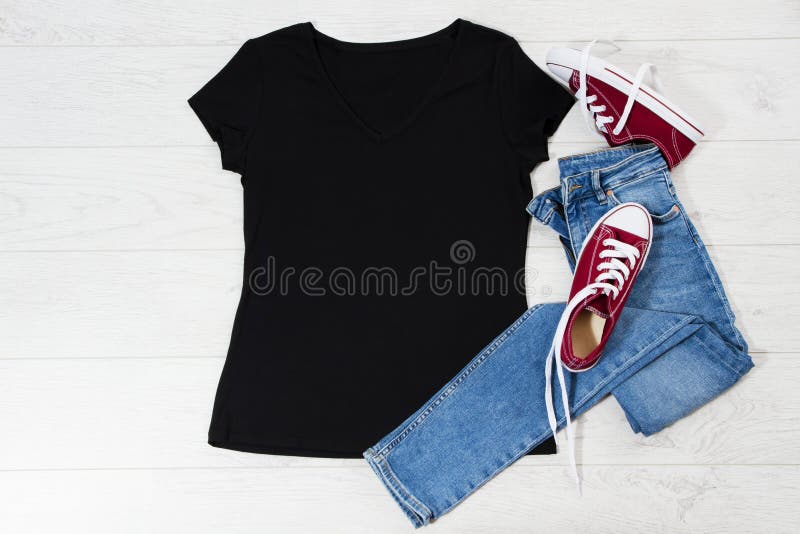 T-shirt zwart en sneakers T-shirt met flatlay-out met zomeraccessoires Jeans en sneakers op houten vloer Kopie