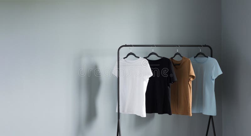 https://thumbs.dreamstime.com/b/t-shirts-neutral-colors-black-hanger-against-gray-wall-291115552.jpg