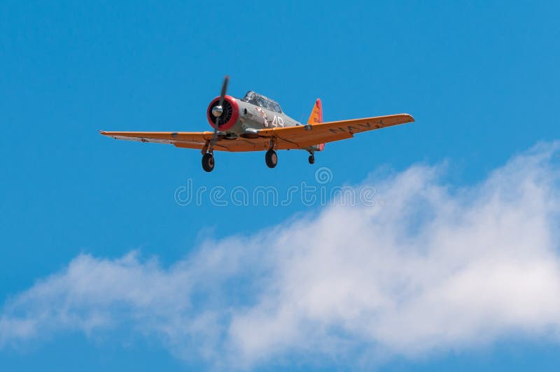 EDEN PRAIRIE, MN - JULY 16, 2016: AT-6 Texan airplane above clouds with landing gear down at air show. The AT-6 Texan was primarily used as trainer aircraft during and after World War II.