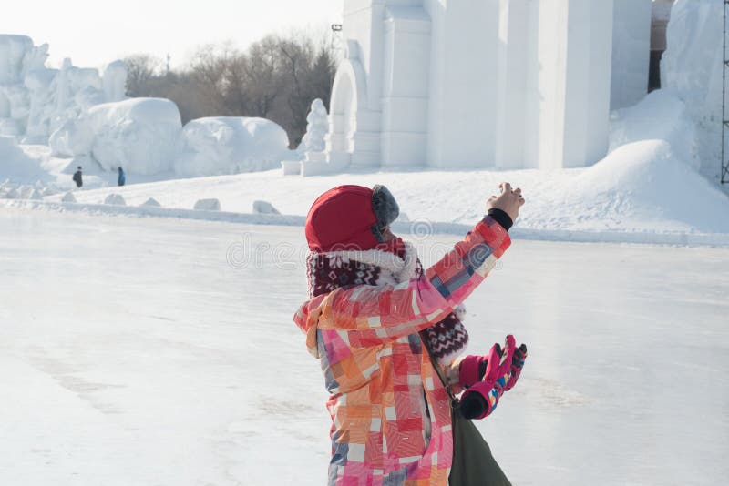 Ta selfies - kvinna utsträckt hand som tar fotoet på den harbin snöfestivalen som fryser förkylning royaltyfri fotografi Ta selfies - kvinna utsträckt hand som tar fotoet på den harbin snöfestivalen som fryser förkylning royaltyfri fotografi