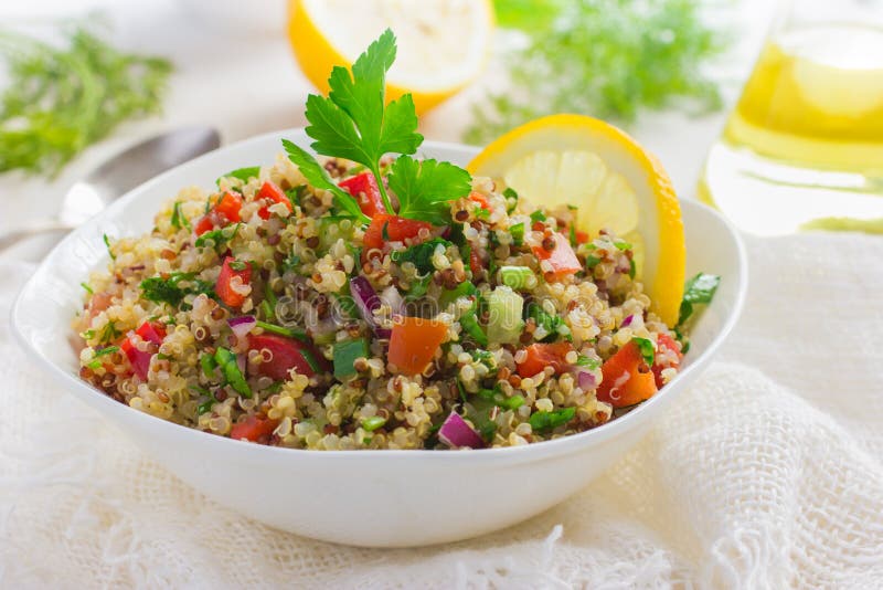 Taboulé-Salat mit quinoa, Petersilie und Gemüse auf weißem hintergrund.