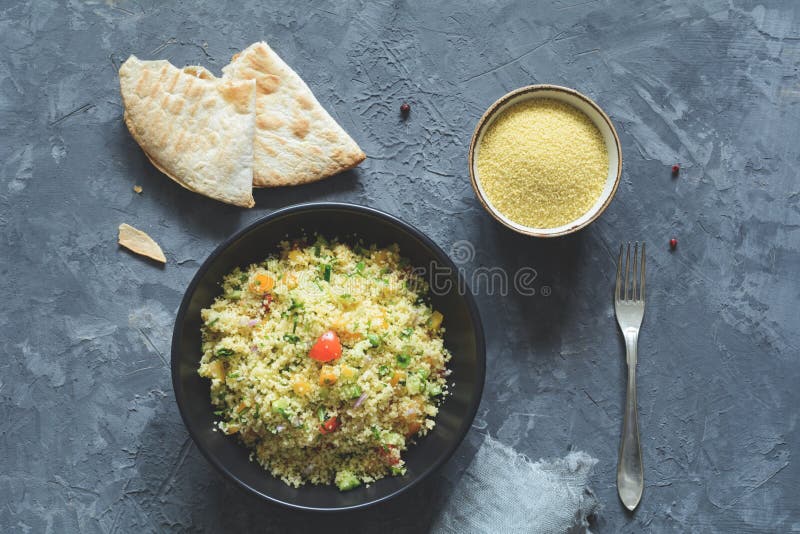 Tabbouleh z cous cous i arabskim flatbread na betonowym tle zdjęcie royalty free Tabbouleh z cous cous i arabskim flatbread na betonowym tle zdjęcie royalty free
