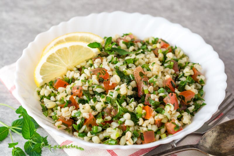 Tabboulehsalade met bulgur, tomaten, peterselie, groene ui en munt in plaat op grijze steenlijst stock afbeeldingen Tabboulehsalade met bulgur, tomaten, peterselie, groene ui en munt in plaat op grijze steenlijst stock afbeeldingen