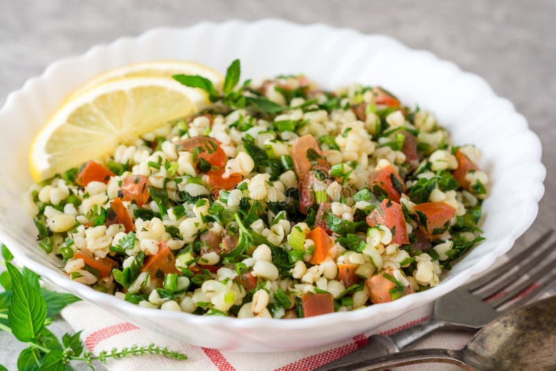 Tabboulehsalade met bulgur, tomaten, peterselie, groene ui en munt in plaat op grijze steenlijst stock afbeeldingen Tabboulehsalade met bulgur, tomaten, peterselie, groene ui en munt in plaat op grijze steenlijst stock afbeeldingen