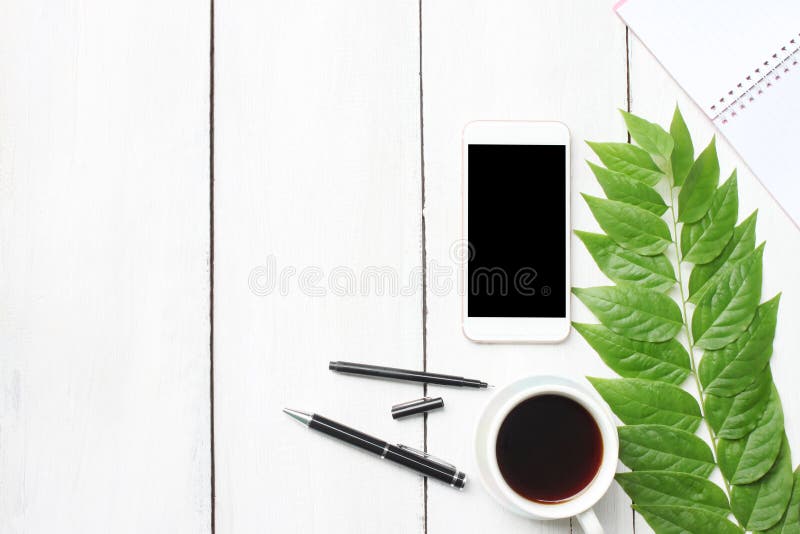 Tabela de madeira branca da mesa da vista superior com fontes do smartphone e co fotos de stock Tabela de madeira branca da mesa da vista superior com fontes do smartphone e co fotos de stock