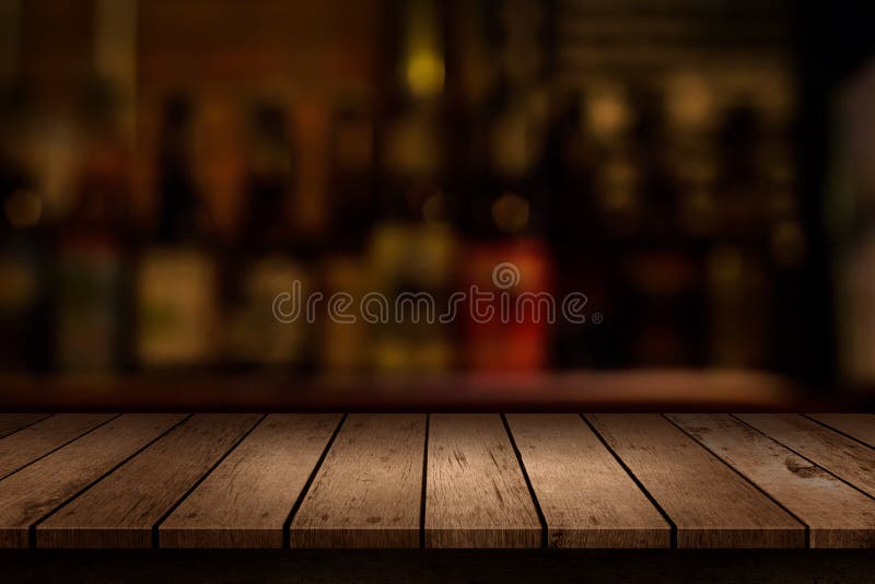 Tabela de madeira com uma vista da barra borrada das bebidas