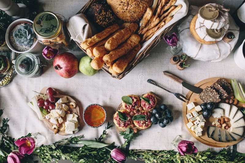 Tabela de piquenique: queijo de cabra cortado, dorblu, pão, uvas, pera, avelã foto de stock Tabela de piquenique: queijo de cabra cortado, dorblu, pão, uvas, pera, avelã foto de stock