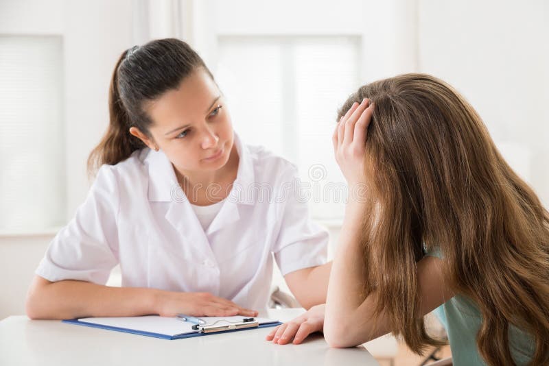 Tabela do doutor Comforting Patient At fotografia de stock Tabela do doutor Comforting Patient At fotografia de stock