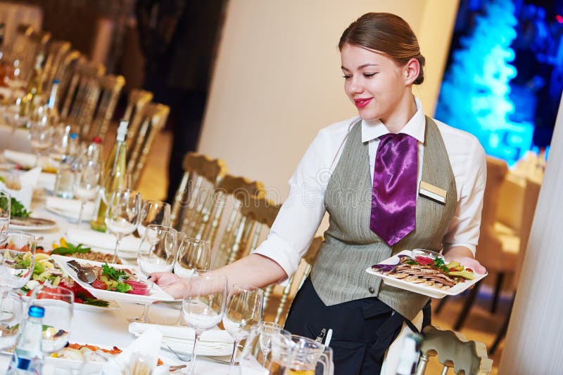 Garçonete De Restaurante Servindo Mesa Com Comida Imagem de Stock