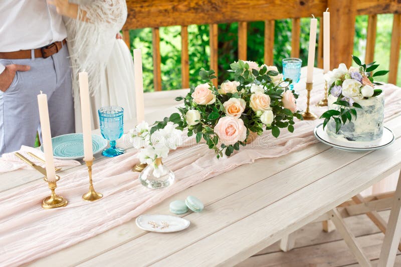 Tabela no jardim, arranjo floral da decoração do casamento, velas no vintage do estilo em exterior Bolo de casamento com flores fotos de stock Tabela no jardim, arranjo floral da decoração do casamento, velas no vintage do estilo em exterior Bolo de casamento com flores fotos de stock