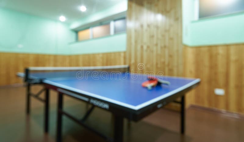 Tabela, raquetes e bolas borradas do pong do sibilo em um salão de esporte imagem de stock royalty free Tabela, raquetes e bolas borradas do pong do sibilo em um salão de esporte imagem de stock royalty free