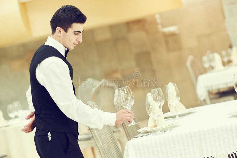 Tabell för bankett för uppassaremanportion på restaurangen royaltyfri fotografi Tabell för bankett för uppassaremanportion på restaurangen royaltyfri fotografi