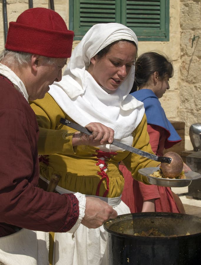 MDINA, MALTA - APR10- Woman preparing traditional food during medieval reenactment in the old city of Mdina in Malta April 10, 2010. MDINA, MALTA - APR10- Woman preparing traditional food during medieval reenactment in the old city of Mdina in Malta April 10, 2010