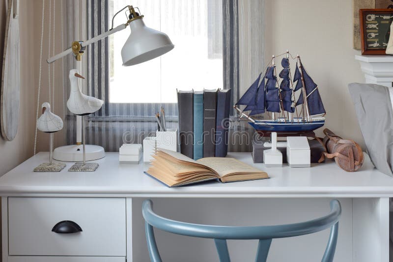 Tabla blanca con los libros y la lámpara de madera de la silla en zona de trabajo moderna foto de archivo Tabla blanca con los libros y la lámpara de madera de la silla en zona de trabajo moderna foto de archivo