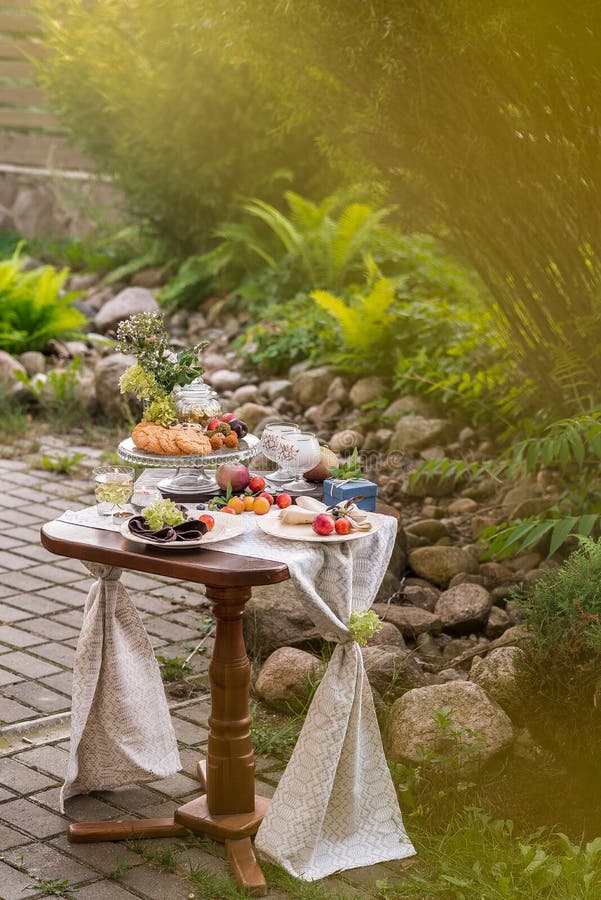 Tabla con la invitación festiva y mantel en el jardín del verano fotografía de archivo Tabla con la invitación festiva y mantel en el jardín del verano fotografía de archivo