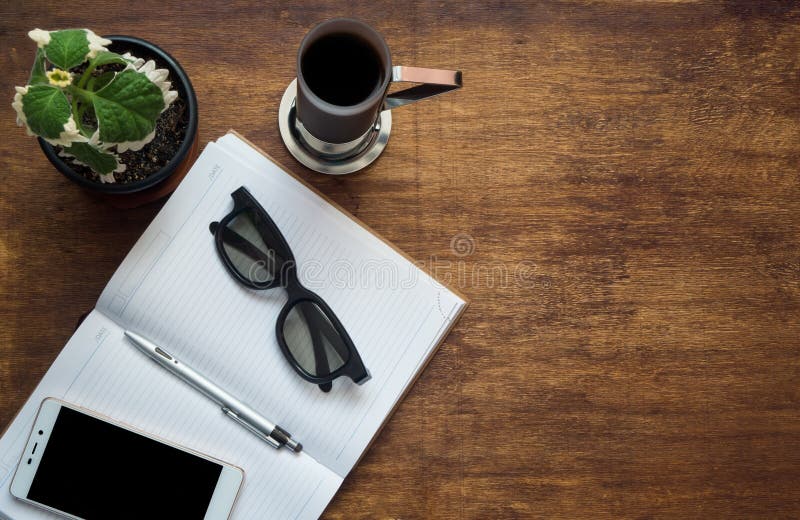 Tabla del escritorio de oficina con el teléfono de la pantalla en blanco, la pluma del cuaderno y la taza de café elegantes Visió imágenes de archivo libres de regalías Tabla del escritorio de oficina con el teléfono de la pantalla en blanco, la pluma del cuaderno y la taza de café elegantes Visió imágenes de archivo libres de regalías