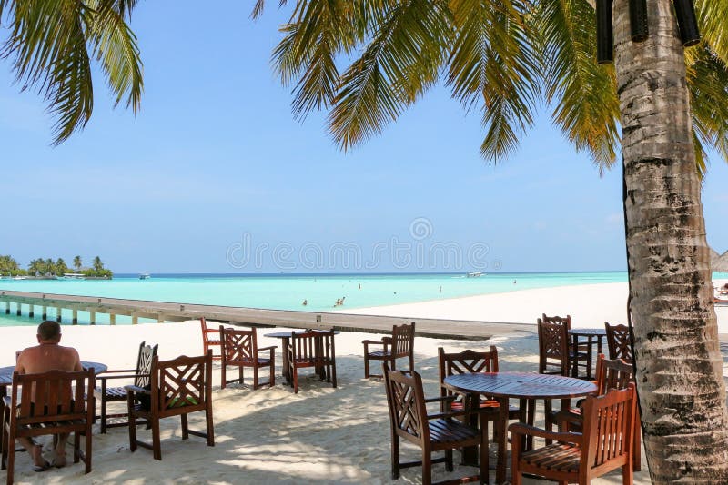 Tabla y sillas al aire libre románticas del restaurante en la playa en el sol foto de archivo libre de regalías Tabla y sillas al aire libre románticas del restaurante en la playa en el sol foto de archivo libre de regalías