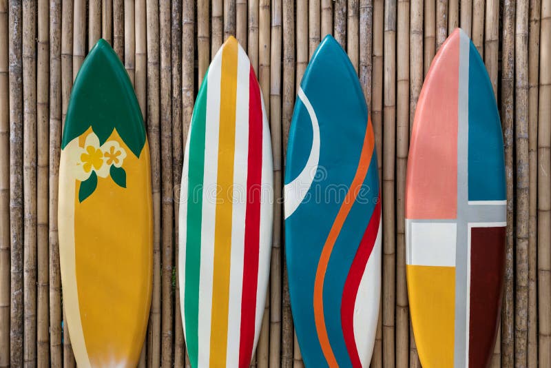 Tablas de surf de colores en la pared de madera de bambú