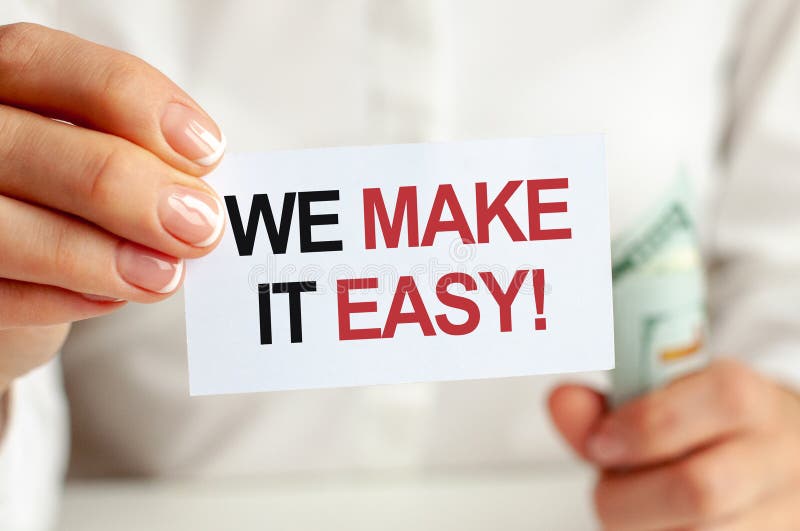 On the table are bills, a bundle of dollars and a sign on which it is written - WE MAKE IT EASY. Finance and economics concept stock image