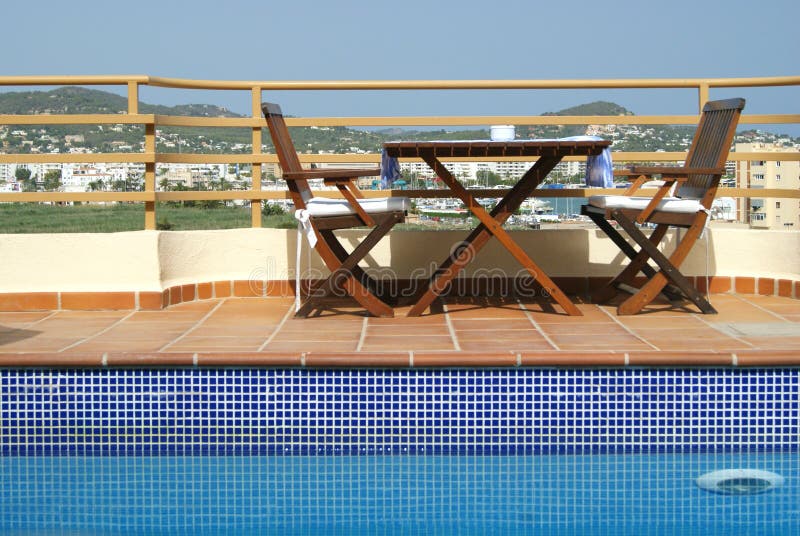 Table and Chairs by Swimming Pool in Roof Garden i