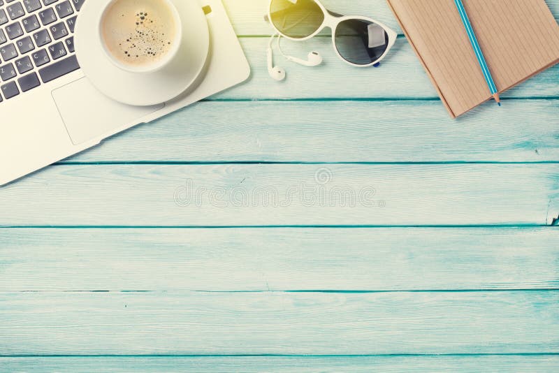 Table de bureau avec l'ordinateur portable, le café et les lunettes de soleil image stock Table de bureau avec l'ordinateur portable, le café et les lunettes de soleil image stock