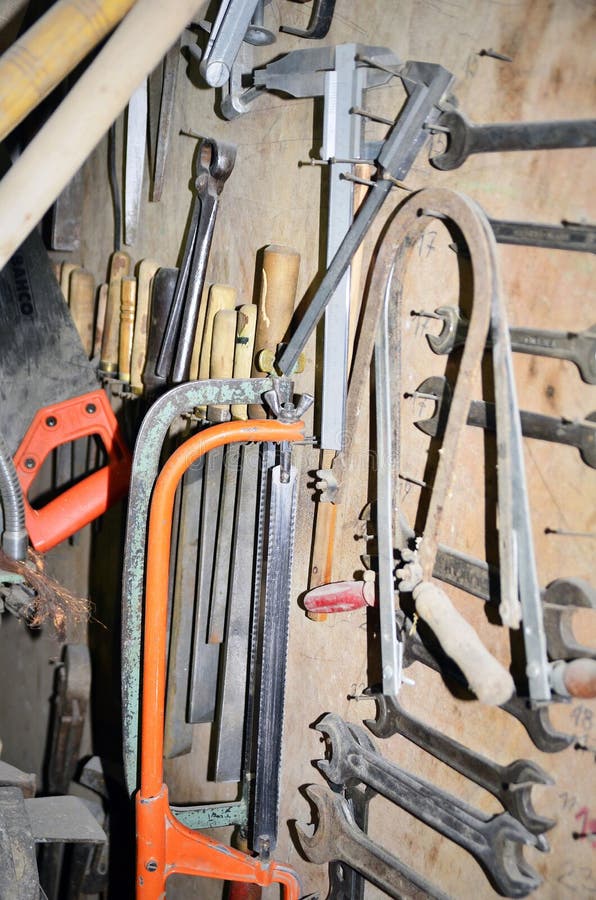 Table de travail d'un charpentier avec accrocher de beaucoup d'olds d'outils. Table de travail d'un charpentier avec beaucoup d'olds d'outils accrochant à l'arrière-plan
