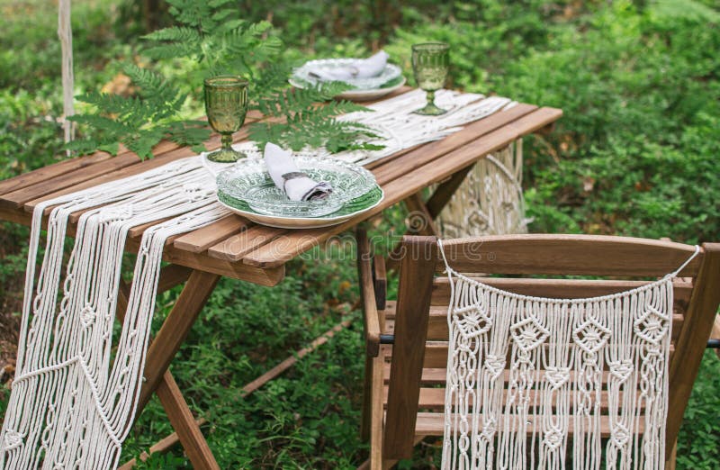 Boho style wedding reception dinning table with macrame tablecloth, decoration on a rustic wooden table. Boho style wedding reception dinning table with macrame tablecloth, decoration on a rustic wooden table