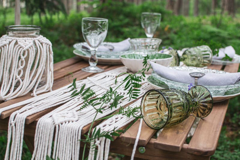 Boho style wedding reception dinning table with macrame tablecloth, decoration on a rustic wooden table. Boho style wedding reception dinning table with macrame tablecloth, decoration on a rustic wooden table
