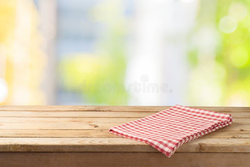 Empty wooden table with table cloth over abstract bokeh background. Mock up for display or montage product. Empty wooden table with table cloth over abstract bokeh background. Mock up for display or montage product