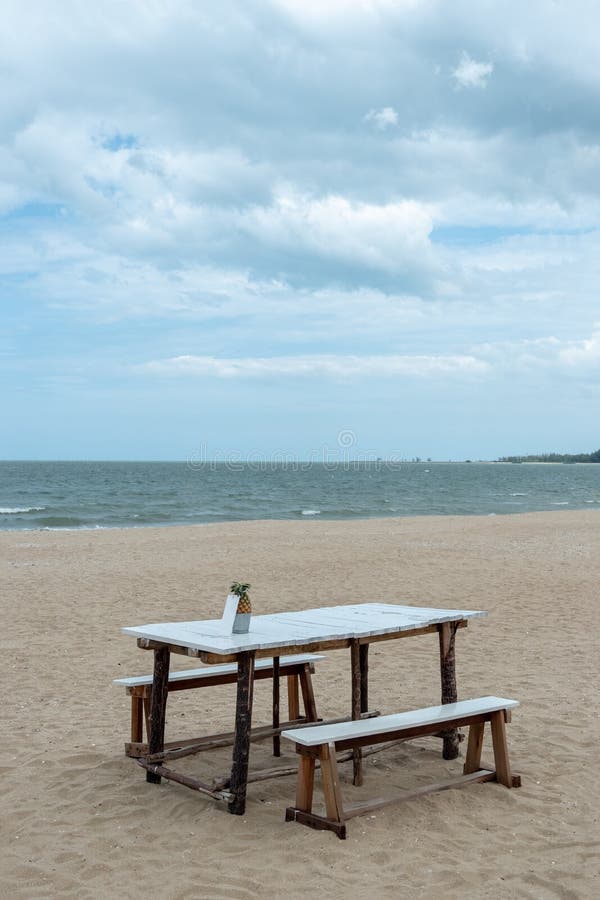 Table et chaise en bois vides sur la plage pour dîner en famille avec la mer bleue photo libre de droits Table et chaise en bois vides sur la plage pour dîner en famille avec la mer bleue photo libre de droits