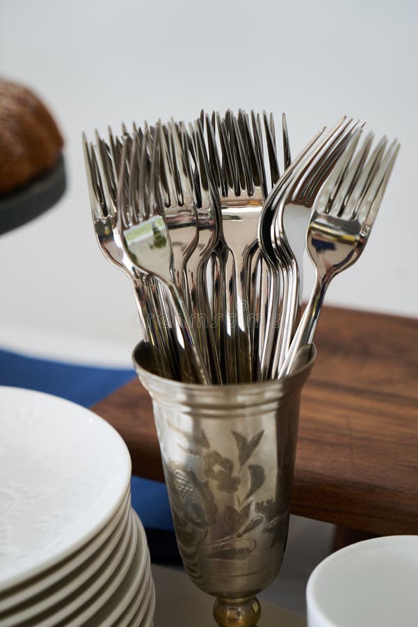 Table with Kitchen Cutlery, Silver Cup with Fork, White Plates and Wood