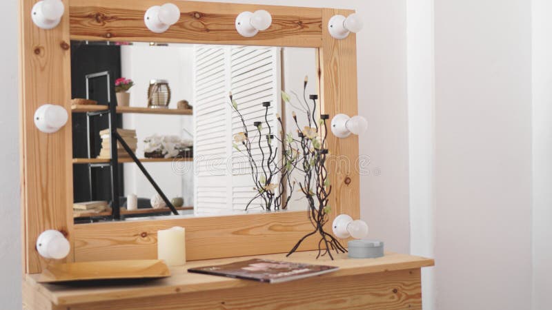 Table with makeup products and mirror near white wall. Dressing room interior stock photo Table with makeup products and mirror near white wall. Dressing room interior stock photo