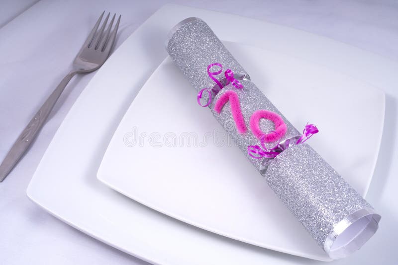 Table Place Setting with a Traditional Cracker for a 70th Birthday royalty free stock photo