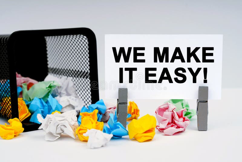 On the table are reporting graphics and a thought plate, inside of which it is written - WE MAKE IT EASY stock photo