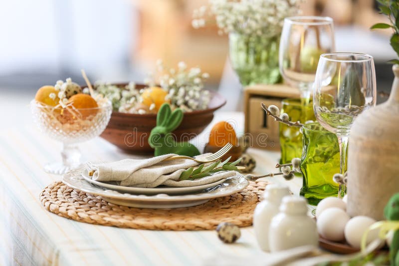 Plates with Napkin, Cutlery and Eucalyptus Branch on Table Served for Easter Celebration Stock