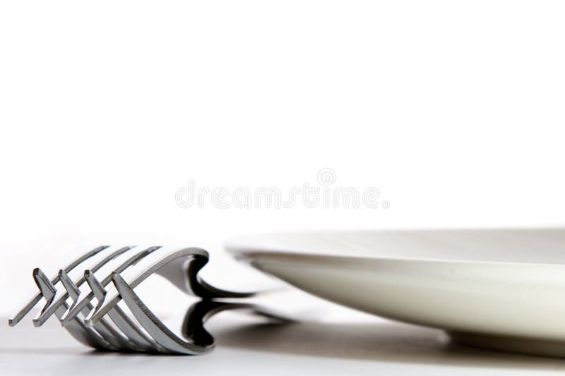 Table Setting. Low angle view of two forks and a plate on a table Table Setting. Low angle view of two forks and a plate on a table