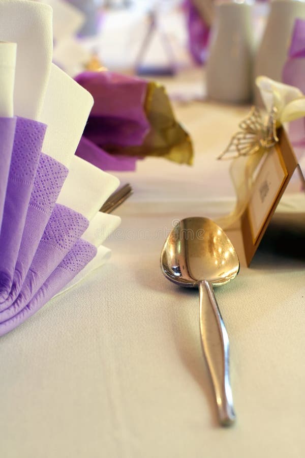 Close crop from a wedding table setting with emphasis on a silver spoon. Close crop from a wedding table setting with emphasis on a silver spoon