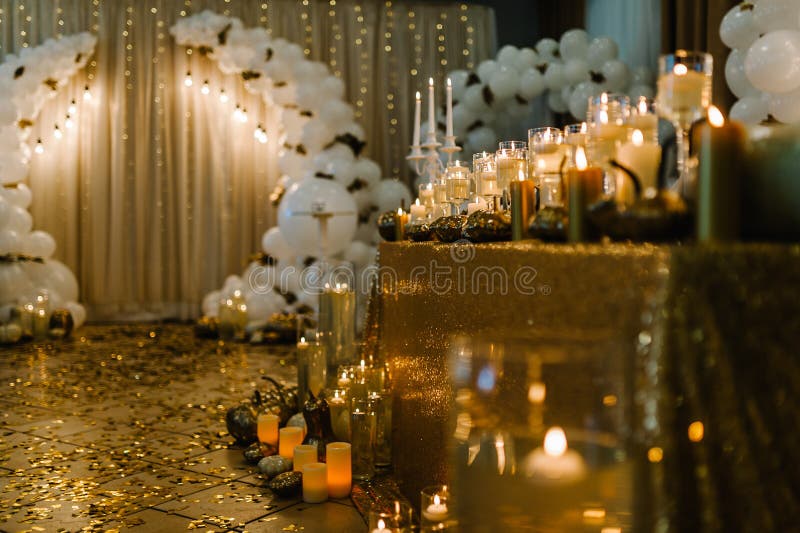 Table setting for a wedding. Decorated arch for the wedding ceremony. White balloons, candles, autumn leaves, and small pumpkins. Autumn location and Halloween decor. Table setting for a wedding. Decorated arch for the wedding ceremony. White balloons, candles, autumn leaves, and small pumpkins. Autumn location and Halloween decor.