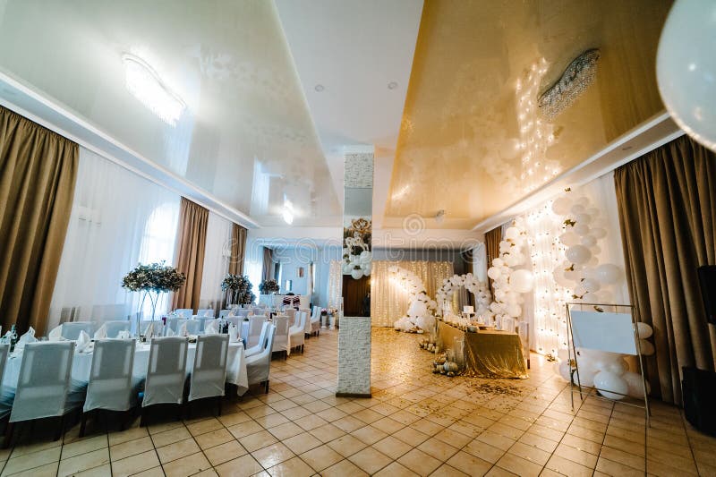 Table setting for wedding. Decorated arch for wedding ceremony. White balloons, candles, autumn leaves and small pumpkins. Autumn location and Halloween decor