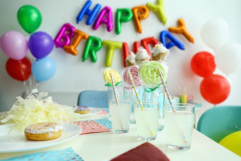 Table with treats and HAPPY BIRTHDAY made of colorful balloon letters in living room. Table with treats and phrase HAPPY BIRTHDAY made of colorful balloon stock photo Table with treats and HAPPY BIRTHDAY made of colorful balloon letters in living room. Table with treats and phrase HAPPY BIRTHDAY made of colorful balloon stock photo