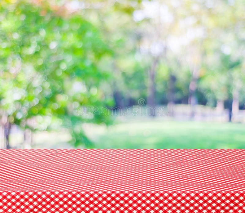 Table with red tablecloth and blur trees with bokeh background, product display montage. Table with red tablecloth and blur trees with bokeh background, product display montage