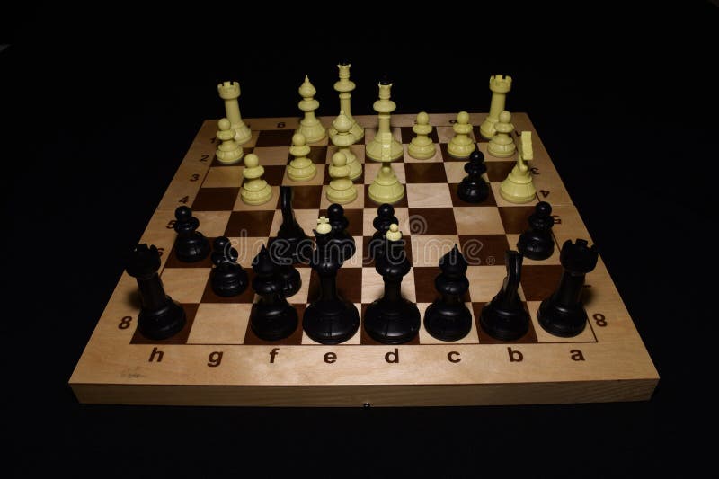 Tablero de ajedrez de madera y piezas de ajedrez negras como un fondo del juego fotos de archivo libres de regalías Tablero de ajedrez de madera y piezas de ajedrez negras como un fondo del juego fotos de archivo libres de regalías