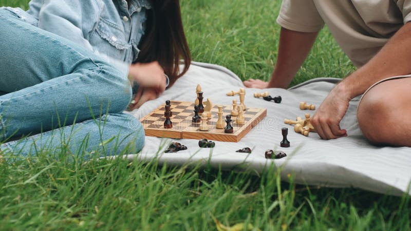 Tablero de ajedrez. un divertido juego de ajedrez de verano en el parque para una pareja joven que disfruta de un agradable día ju almacen de video