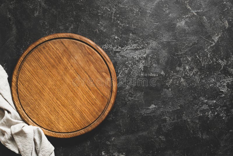 Tablero de la tabla de cortar de madera o de la pizza en fondo concreto negro imagen de archivo