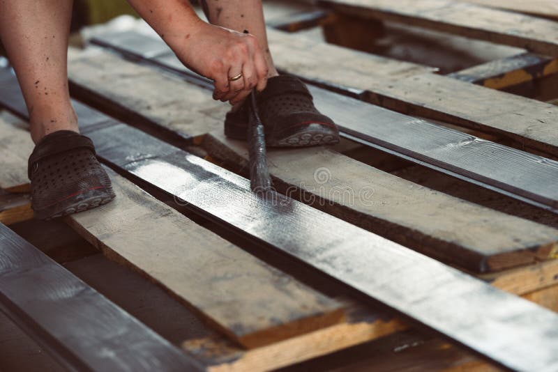Tableros de pintura con un cepillo sostenido a disposición Gris, pintura de madera de antracita fotografía de archivo libre de regalías Tableros de pintura con un cepillo sostenido a disposición Gris, pintura de madera de antracita fotografía de archivo libre de regalías