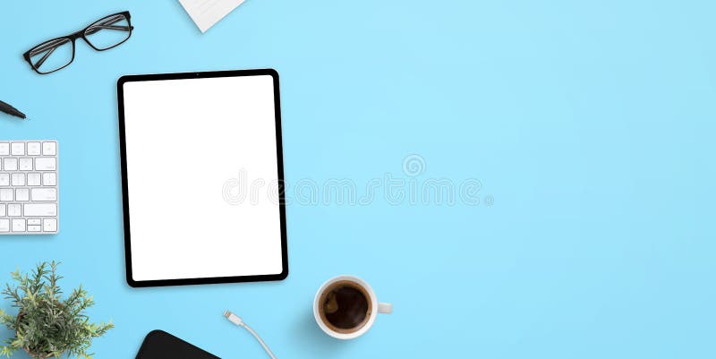 Tablet mockup on blue work desk with plenty of space for text