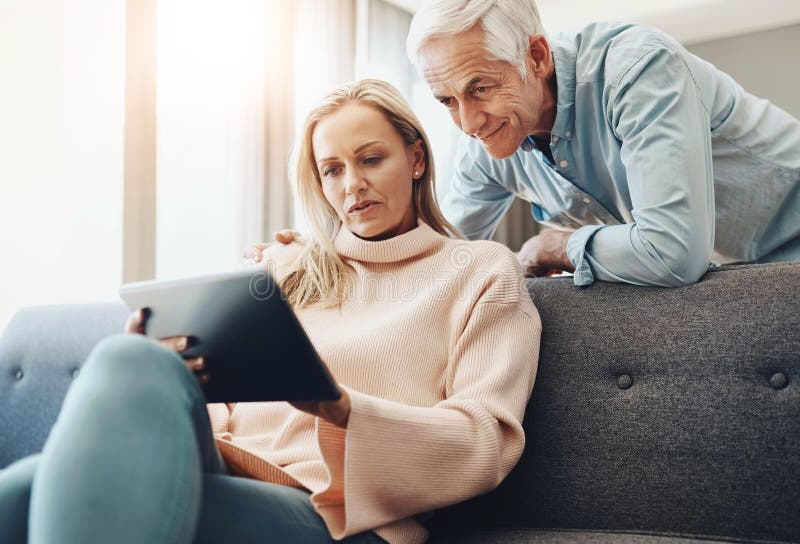 Tablet, planning and couch with couple and internet banking with budget and financial decision. Discussion, marriage and royalty free stock images