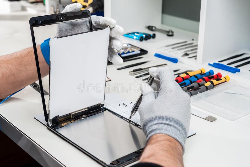 Tecnico di mani riparazione di un usato tablet, contenitore con schermo rotto.