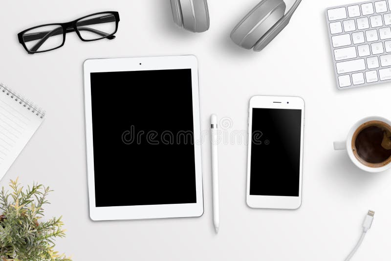 Tableta y teléfono en el escritorio de oficina Pantalla en blanco para la maqueta, el app o la presentación responsiva del sitio